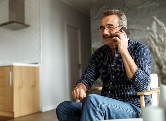 Contact Us man sitting in room on phone