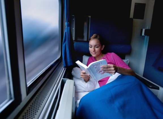 woman reading book in a roomette onboard amtrak