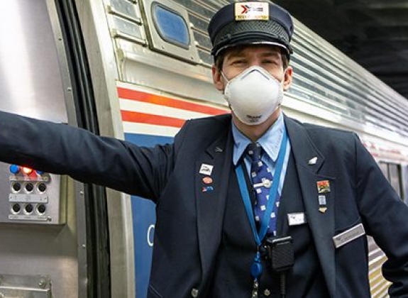 Facial Coverings are Required amtrak attendant in a facial covering