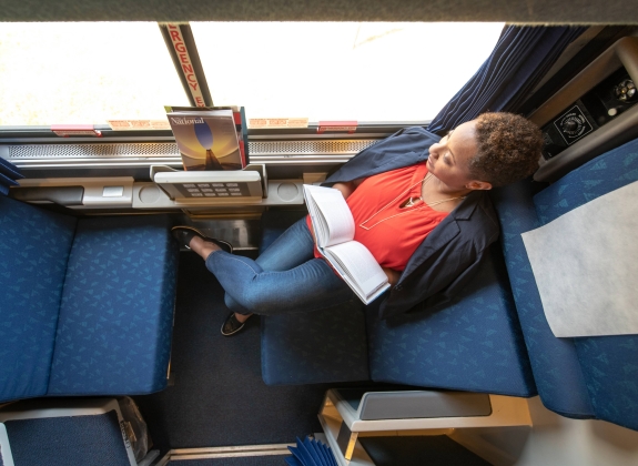 woman reading book in a roomette onboard amtrak