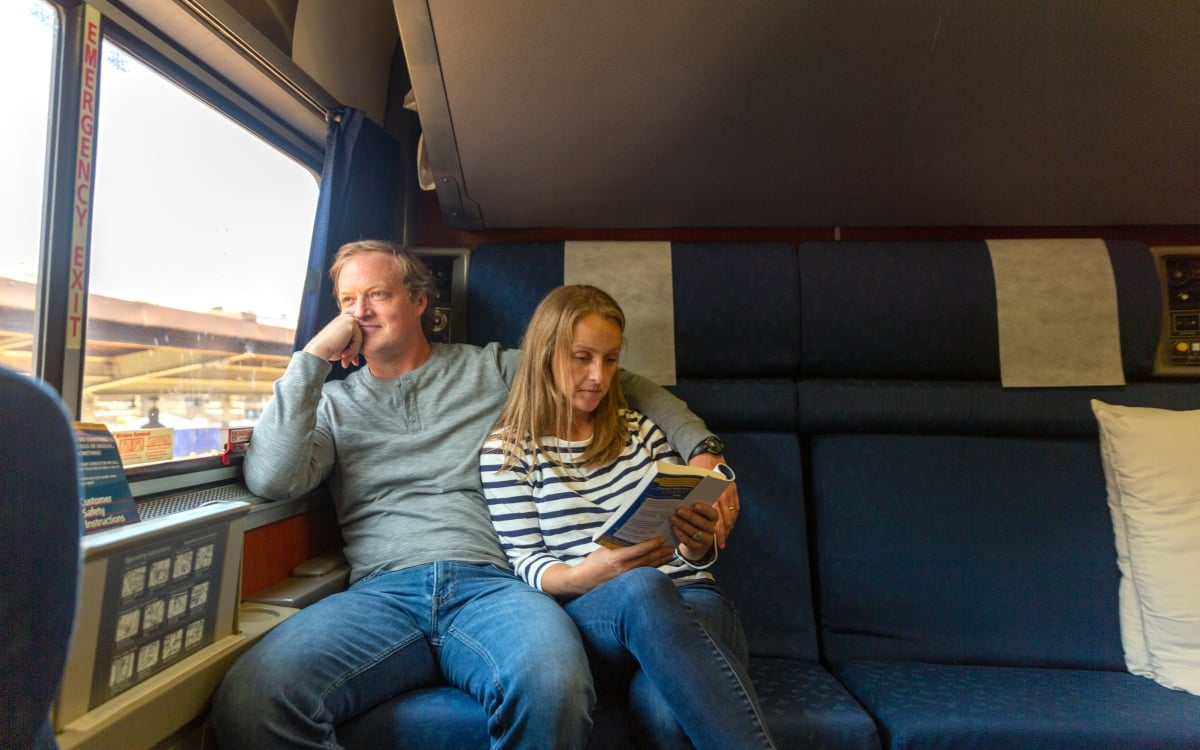 couple in private sleeping room onboard amtrak,man looking out window