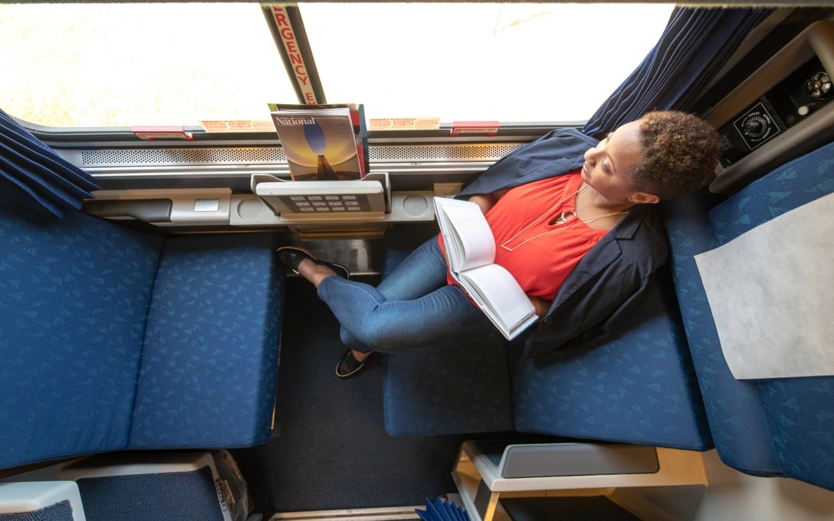 woman reading book in a roomette onboard amtrak