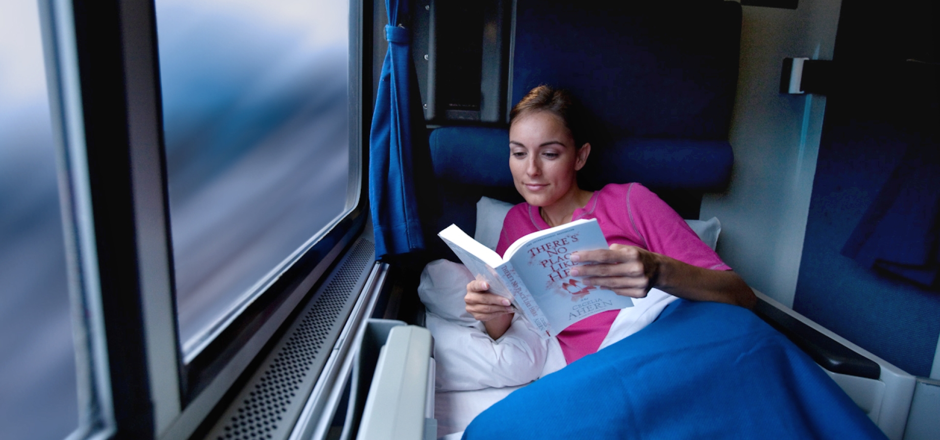 woman reading book in a roomette onboard amtrak