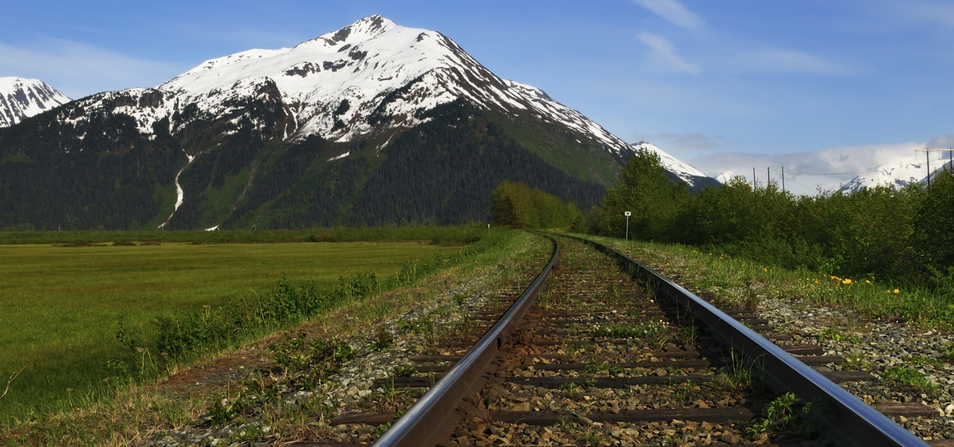 railroad tracks in Alaska by mountain view