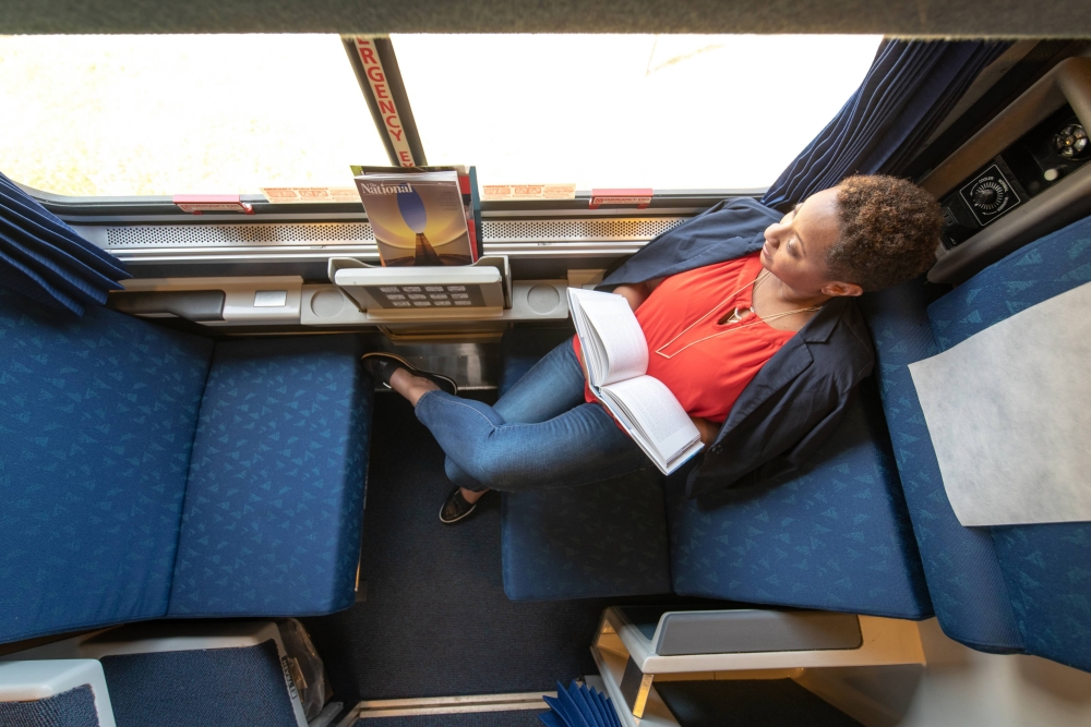 woman reading book in a roomette onboard amtrak